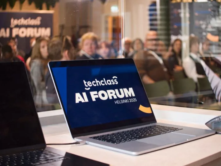 Laptops branded TechClass AI Forum Helsinki 2025 in front of the forum audience